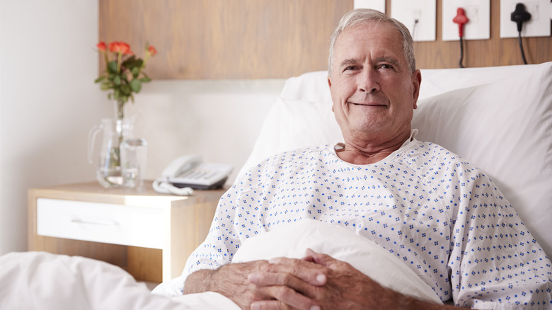 Elderly man sitting up in bed smiling