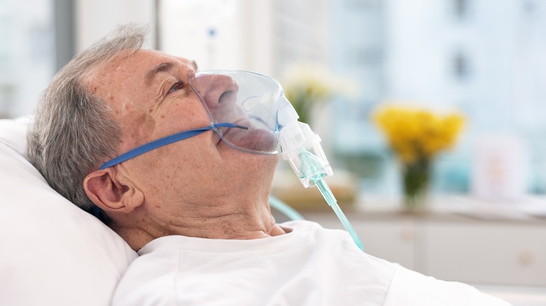 Patient in bed with oxygen mask