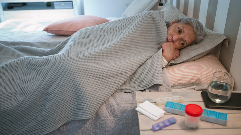 Elderly patient in bed under blanket