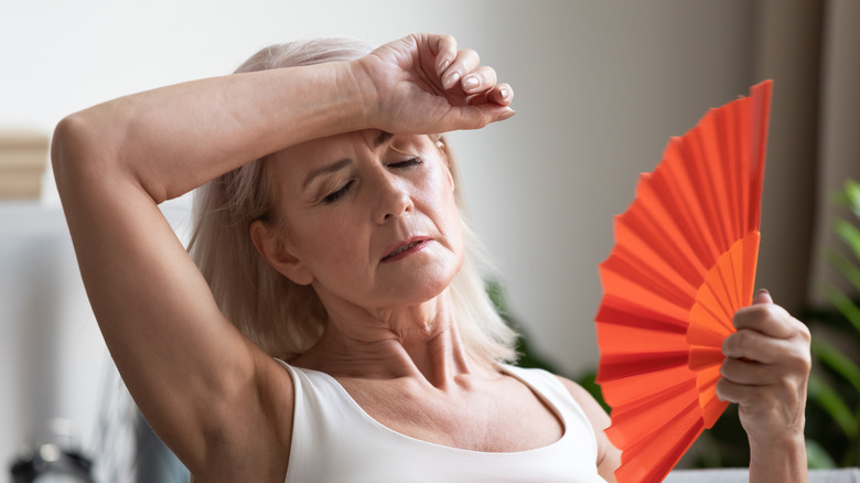 overheated woman fanning herself