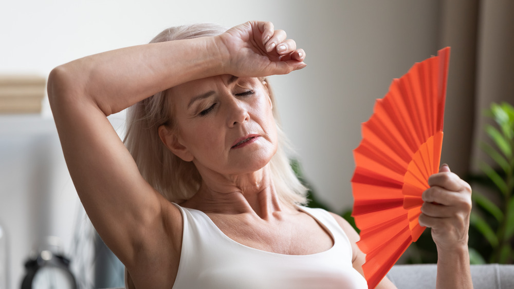 overheated woman fanning herself