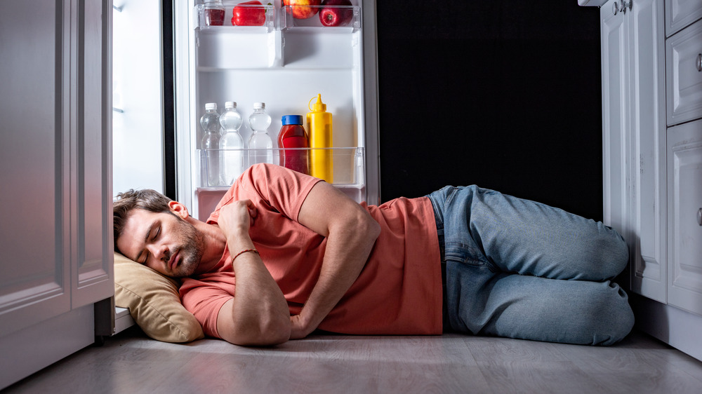 man sleeping in fridge