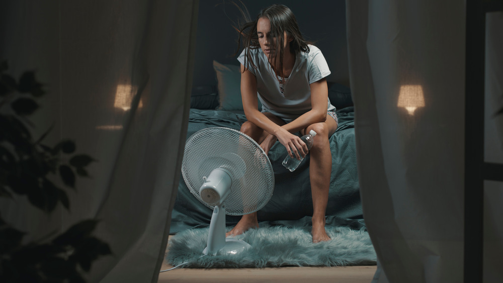 woman sitting in front of fan