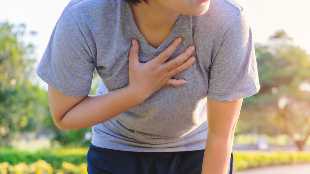 woman holding chest outside