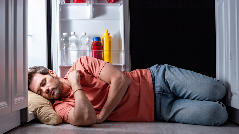 man sleeping in fridge