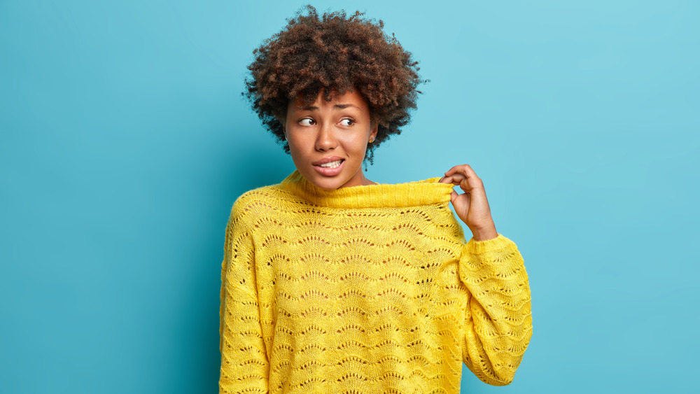 woman pulling neck of sweater