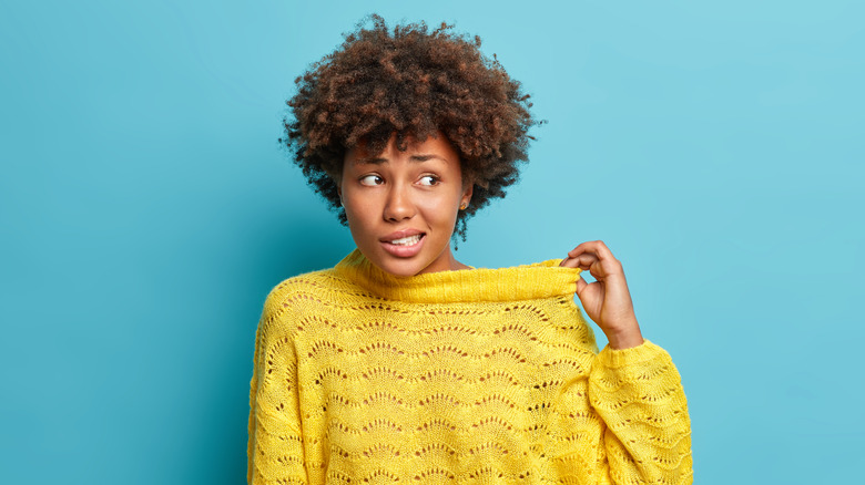 woman pulling neck of sweater