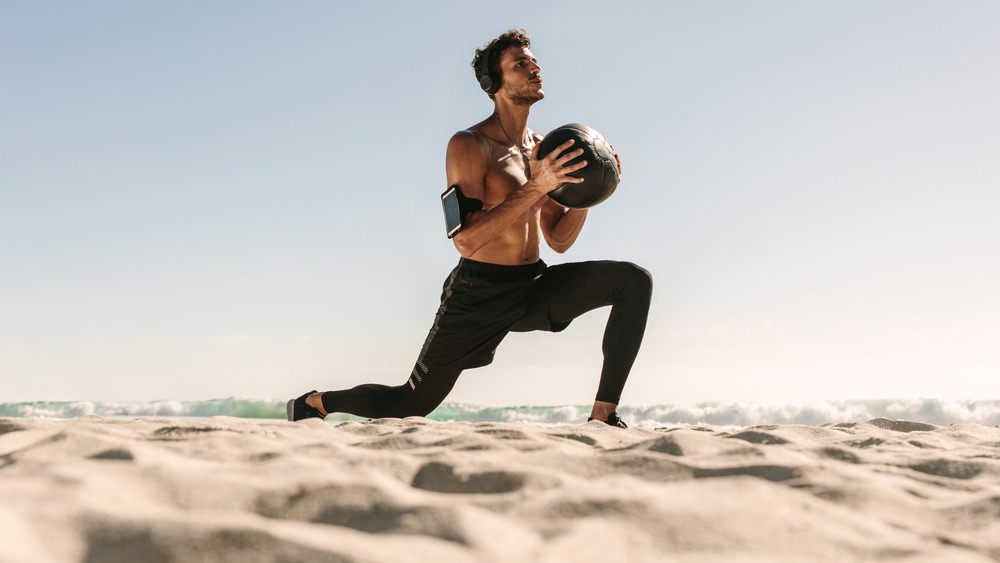 man lunging in sand