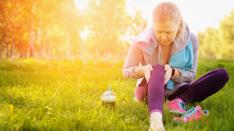 Woman athlete with joint pain sitting in the sunshine