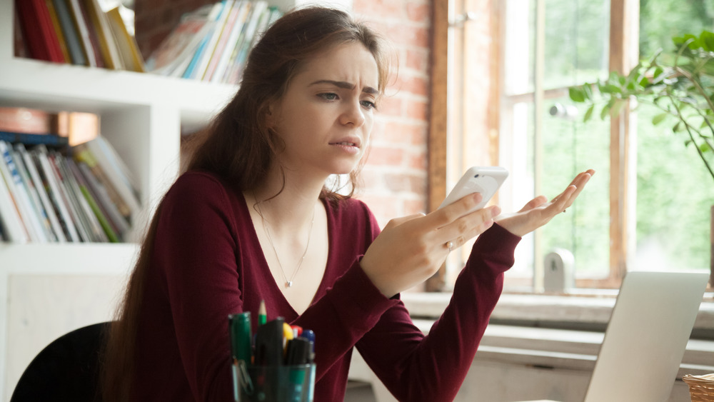 Upset woman looking at phone