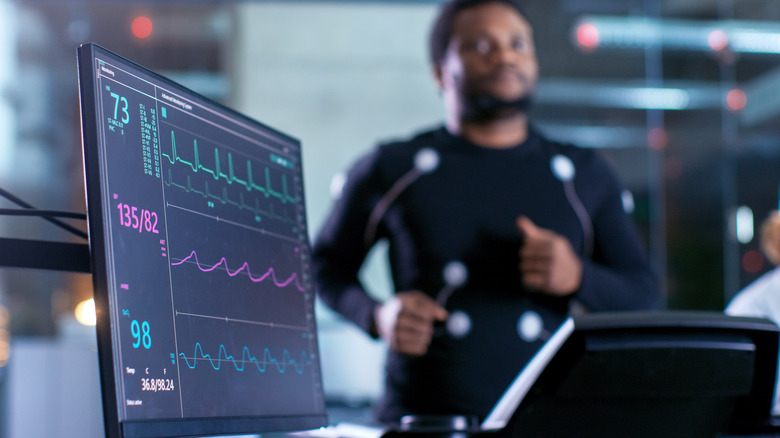 Black man on treadmill connected to heart machine
