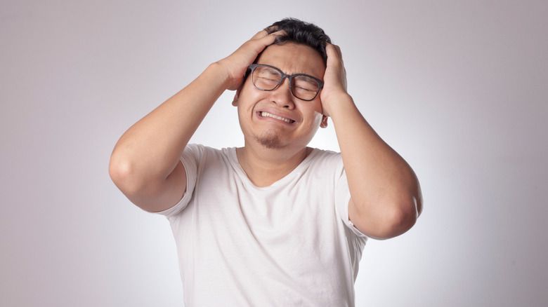 frustrated man holding his head in despair