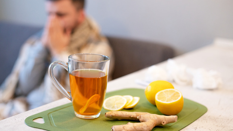 hot tea, lemon and ginger with man in background