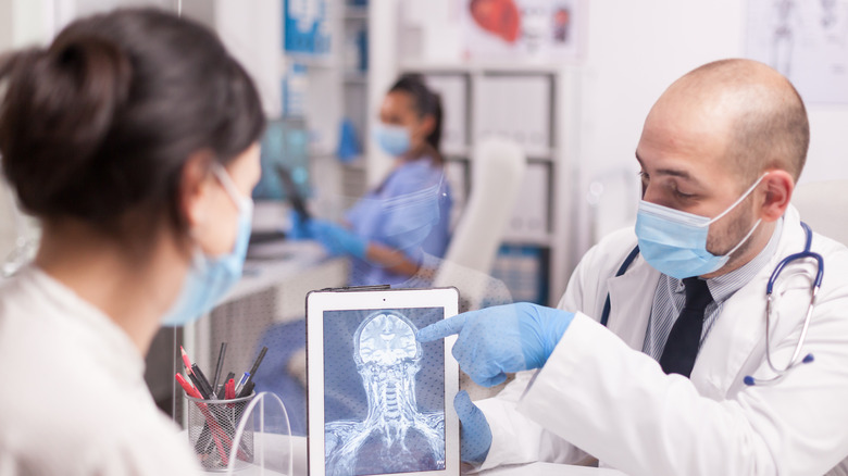 Doctor sitting with patient and analyzing a brain scan