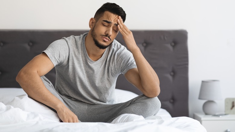 Man in bed with headache