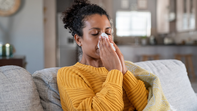 Sick woman blowing nose