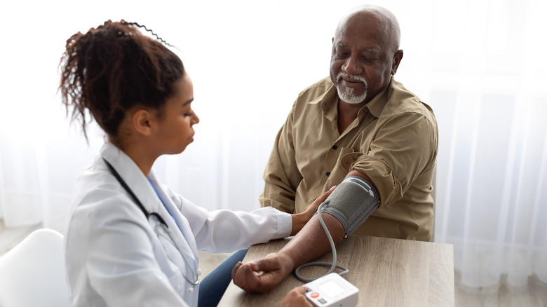 Doctor taking patient's blood pressure