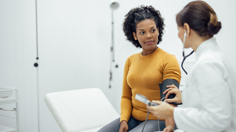 doctor measuring patient blood pressure