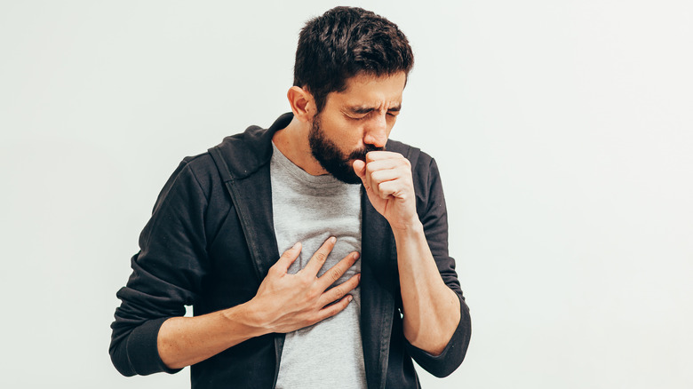 A man has a cough and trouble breathiing