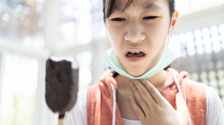 Digusted woman holding partially eaten ice cream bar