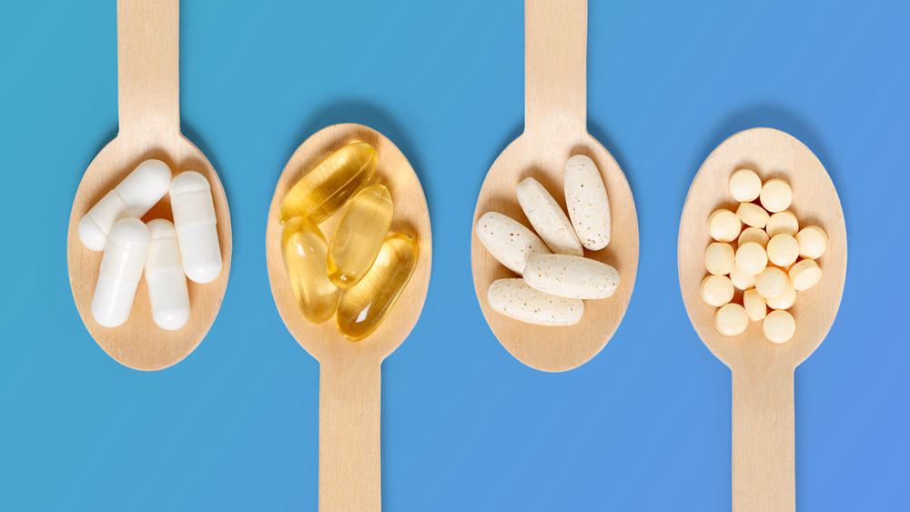 Dietary supplements on wooden spoons 