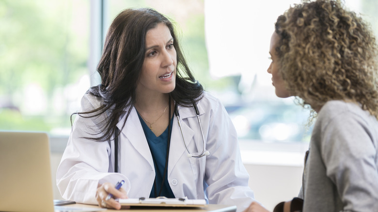 Serious doctor speaking to patient