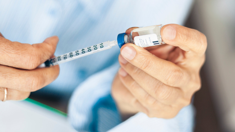 man drawing insulin into syringe