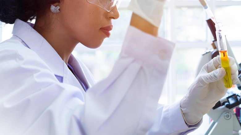 woman performing lab test with test tube