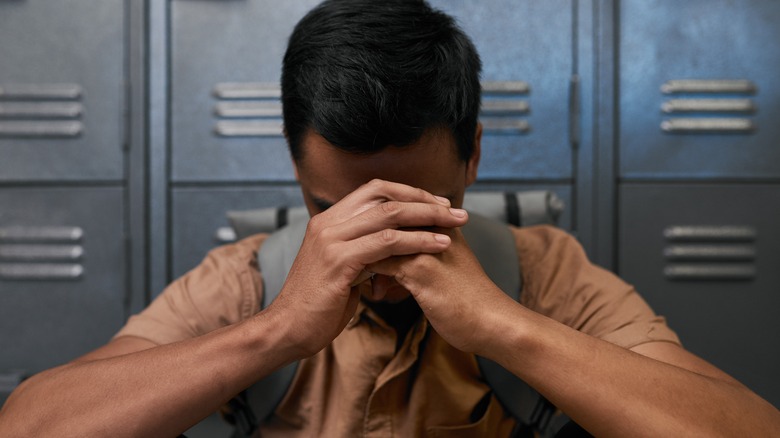 Man resting his forehead against his hands