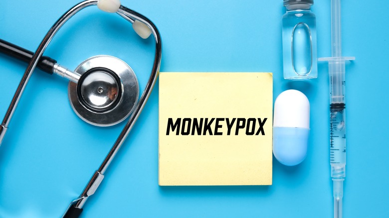 A picture of a notepad with the written word monkeypox, surrounded by stethoscope and medicine