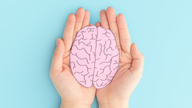 woman holding paper shape of human brain