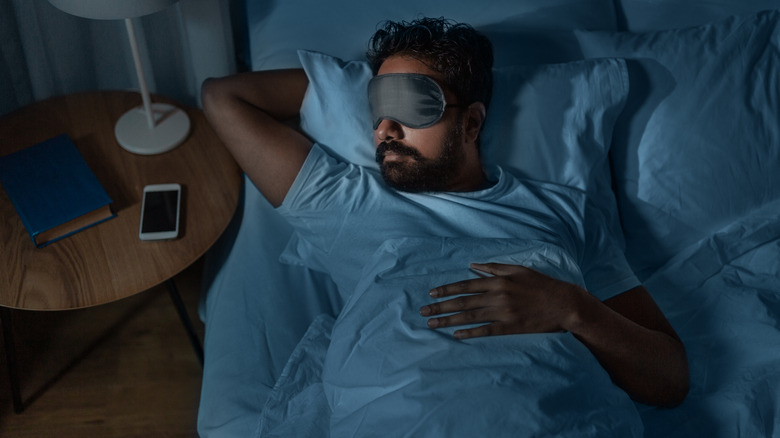 man sleeping wearing eye mask