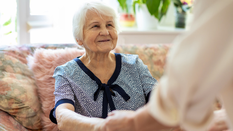 Hands helping up senior woman