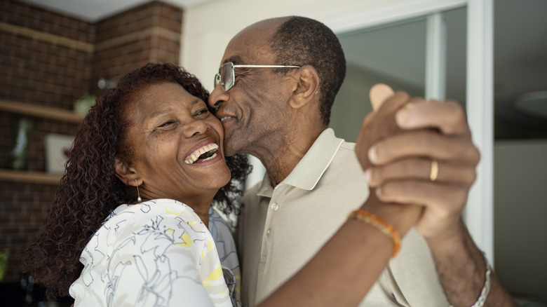 Laughing senior couple dancing together