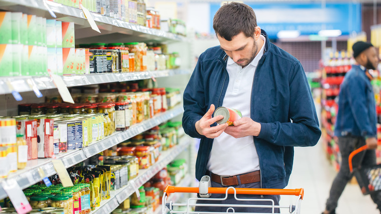 man checking food labels at a grocery store