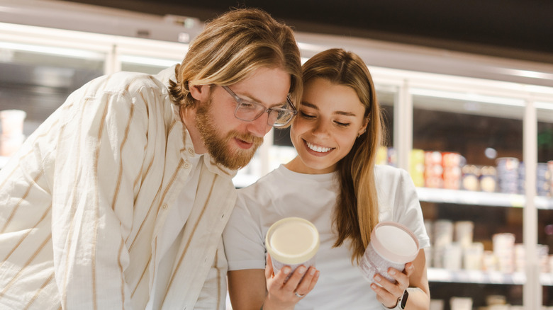 young couple buying dairy items in store