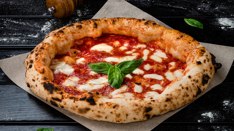 A homemade margherita pizza with tomato sauce, mozzarella, and basil