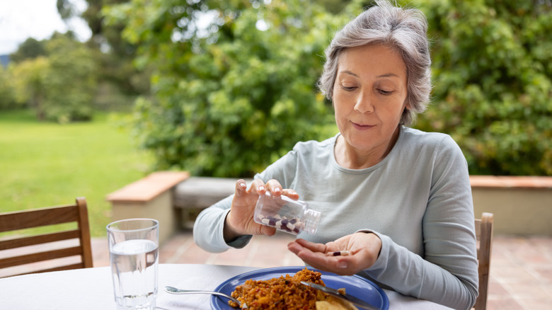 woman taking magnesium supplement with a meal