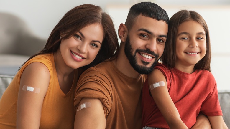 Family of three with vaccine bandage