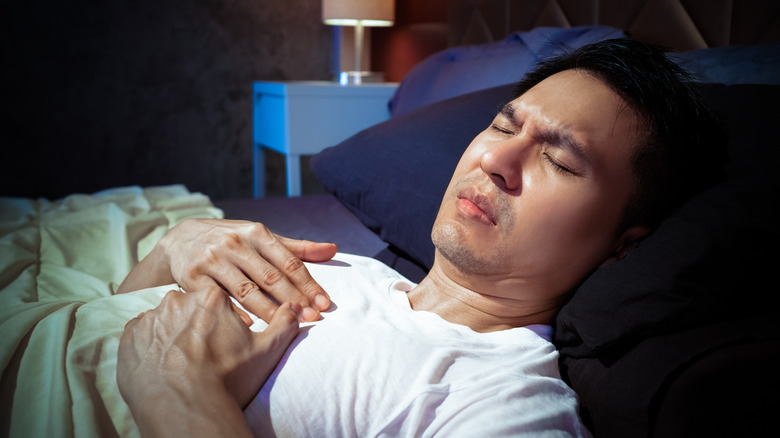 Man lying in bed in pain