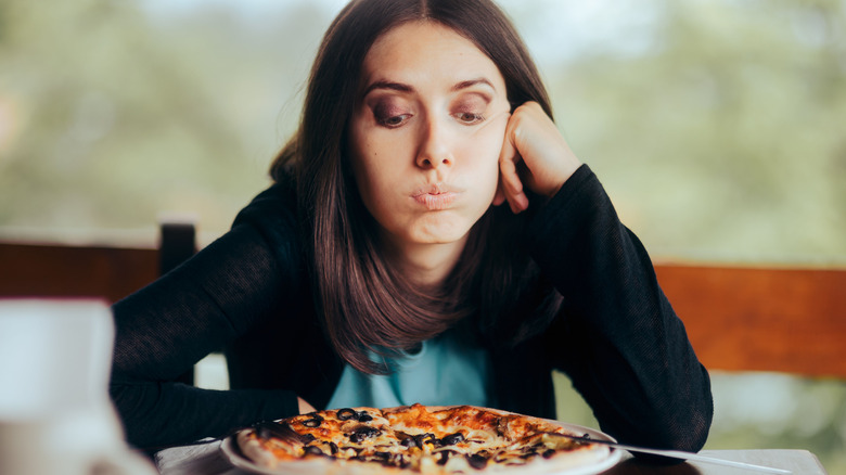 Woman looking at pizza