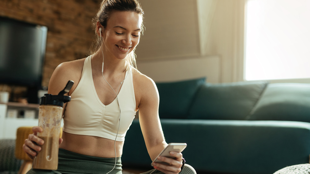 woman drinking chocolate milk shake after workout