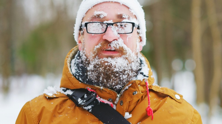 Bearded man is chilly cold snow