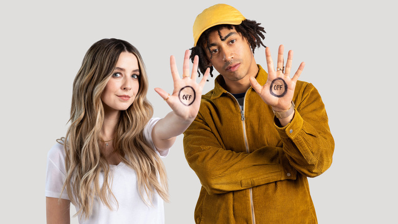 Zoe Sugg and Jordan Stephens with "off" marked on their hands