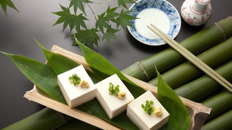 Tofu appetizer with chopsticks and garnish