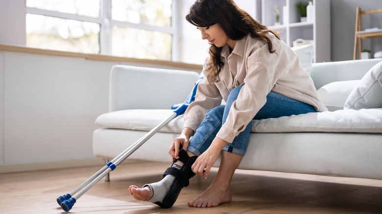 a woman adjusts her ankle brace