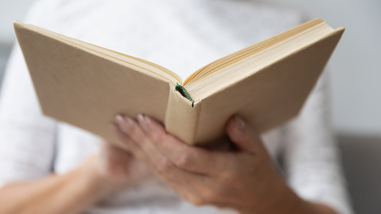 close up of woman holding a book