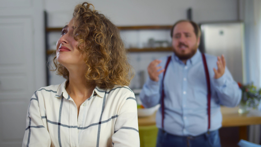 overweight man yelling at crying wife