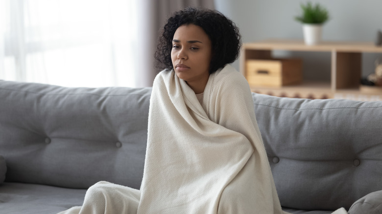Woman feeling cold with blanket