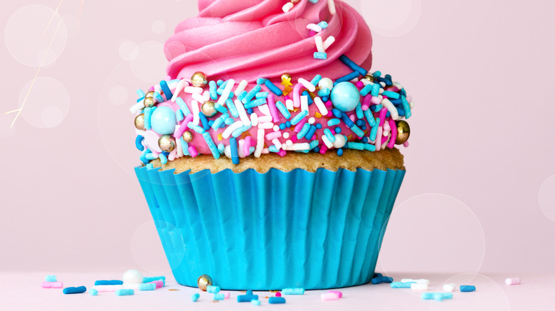 pink frosted cupcake in blue cup
